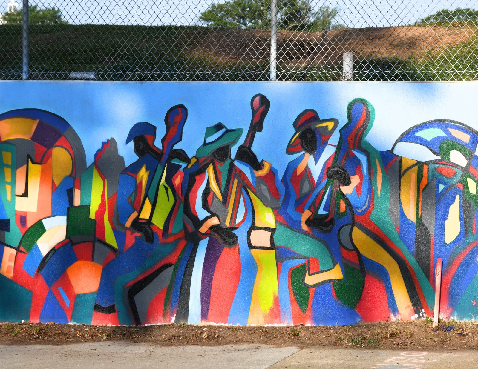 Abstract musicians and dancers panel of the Blandtown mural in bold blue, red, and gold