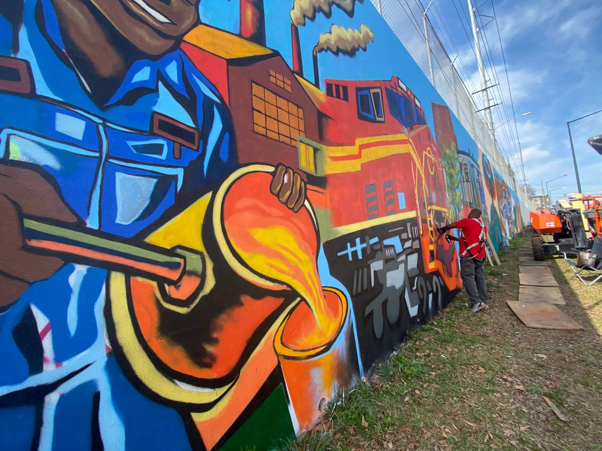 Corey Barksdale painting the industrial-heritage panel of the Blandtown mural, Atlanta