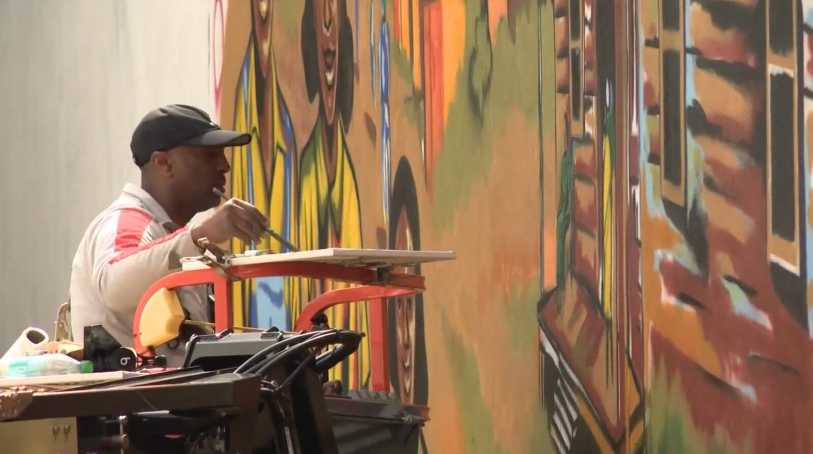 Corey Barksdale painting Blandtown mural detail from a boom lift cherry picker