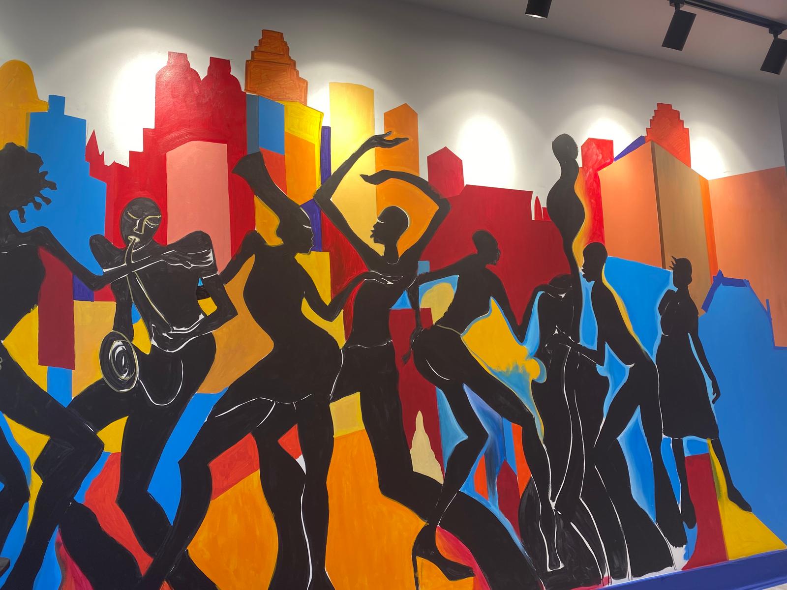 Completed jazz musicians and dancers panel of the Decatur East mural set against a colorful Atlanta skyline