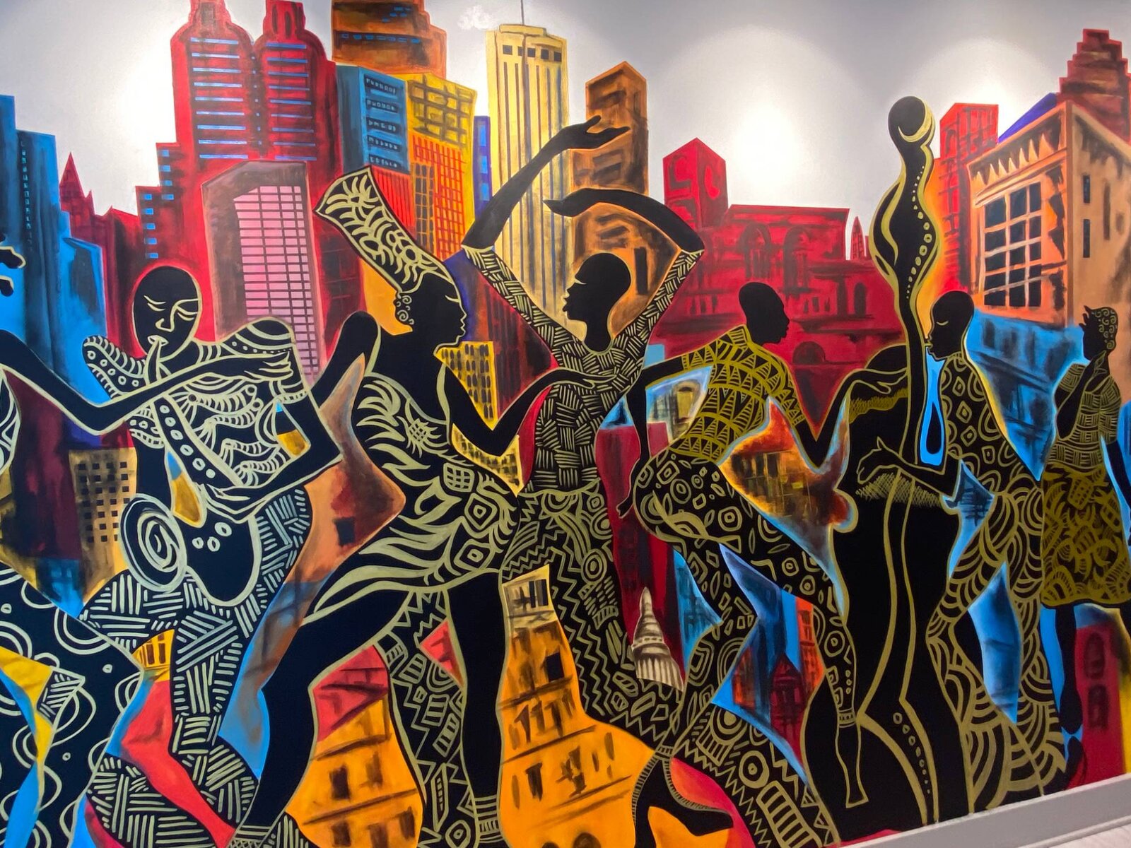Front-facing complete view of the Decatur East mural's silhouetted dancers and musicians against the Atlanta skyline