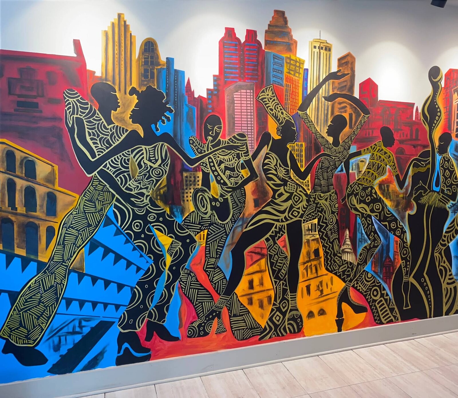 Wide view of the completed Decatur East mural spanning the hallway wall at The Link at Columbia, with silhouetted dancers and musicians against an Atlanta skyline