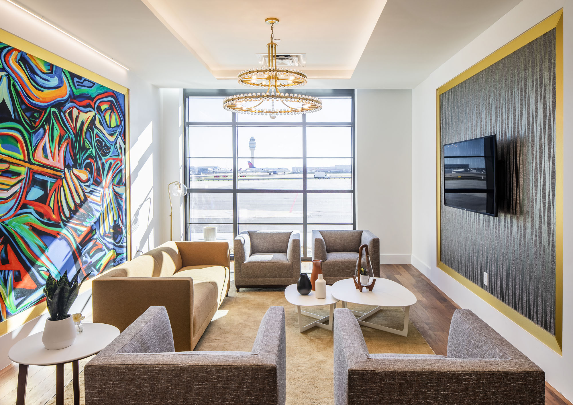 Abstract Corey Barksdale mural inside a Signature Aviation lounge, with the Hartsfield-Jackson tarmac and control tower visible through the window