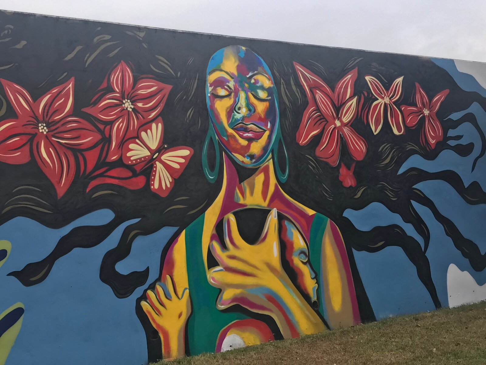 Mother-and-child portrait with red flowers, Pittman Park mural by Pittsburgh Atlanta mural painter Corey Barksdale