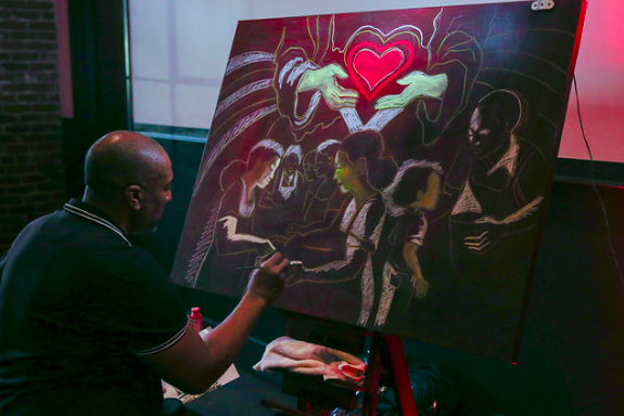 Atlanta live artist Corey Barksdale painting the outline of Heart to God, Hand to Man for The Salvation Army